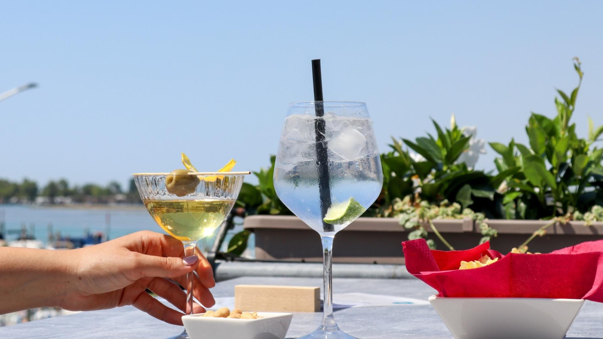 Cocktail con olive e gin tonic con lime, vista mare e snack.