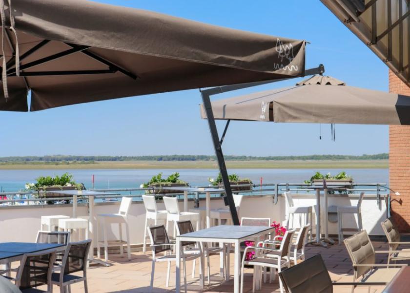 Sunny terrace overlooking the river, with umbrellas and modern chairs.